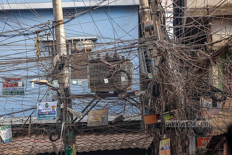 পুরান ঢাকার লালবাগের শহীদ নগর এলাকায় বিদ্যুতের খুঁটিতে থাকা ট্রান্সফরমার চারপাশ ছেয়ে গেছে তারের জঞ্জালে