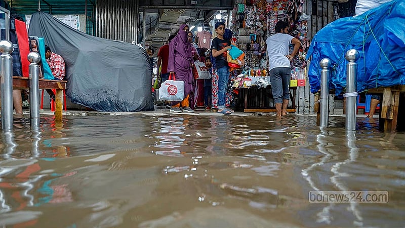 দোকানের সামনে জমে আছে বৃষ্টির পানি, ঈদের আগে বন্ধের দিন শুক্রবার ধানমন্ডি হকার্স মার্কেটে ক্রেতার সংখ্যা তুলনামূলক কম খারাপ আবহাওয়ার কারণে