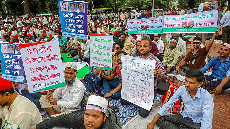 তিন দাবি আদায়ে ঢাকায় কেন্দ্রীয় শহীদ মিনার প্রাঙ্গণে ‘প্রাথমিক সহকারী শিক্ষক সংগঠন ঐক্য পরিষদের’ মহাসমাবেশে প্ল্যাকার্ড হাতে শিক্ষকরা