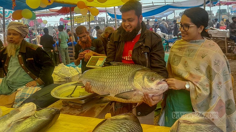 ঐতিহ্যবাহী পোড়াদহ মেলার একটি দোকানে বুধবার বিশাল আকারের কাতল মাছ দেখছেন ক্রেতা-দর্শনার্থীরা