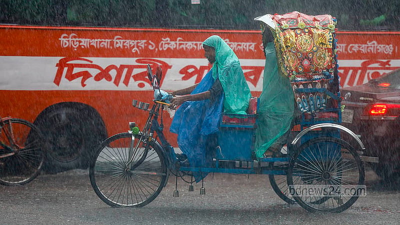 ঢাকার শাহবাগ এলাকায় বৃষ্টি থেকে বাঁচতে পলিথিন গায়ে এক রিকশা চালক