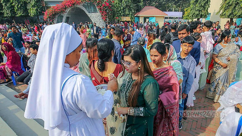 বড়দিনের সকালে বুধবার ঢাকার তেজগাঁওয়ের হলি রোজারি চার্চে প্রার্থনা শেষে দেওয়া হচ্ছে প্রসাদ।