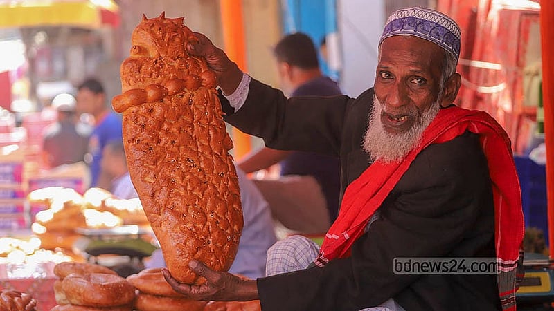 শবে বরাত উপলক্ষে শুক্রবার পুরান ঢাকার চকবাজারের বাহারি নকশা পাউরুটি হাতে এক বিক্রেতা