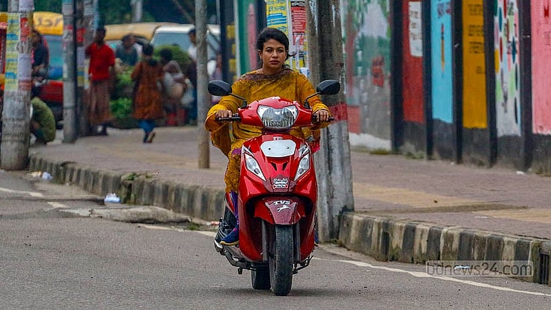 ঢাকার রাস্তায় হেলমেট ছাড়া নারীদেরও মোটরসাইকেল চালাতে দেখা যায়