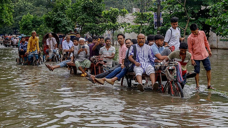 ঢাকায় মঙ্গলবার মধ্যরাত থেকে মুষলধারে বৃষ্টিতে তলিয়ে যায় নিউ মার্কেট এলাকার সড়ক। ফলে অনেক মানুষ সড়ক পার হন ভ্যানে চড়ে