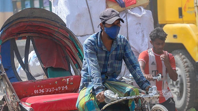 মাস্ক পরে রিকশা চালাচ্ছেন চালকরা। ধুলার কারণে রাজধানীর বাবুবাজার-গাবতলী বেড়িবাঁধ সড়কে প্রতিদিনই ভোগান্তি পোহাতে হচ্ছে তাদের