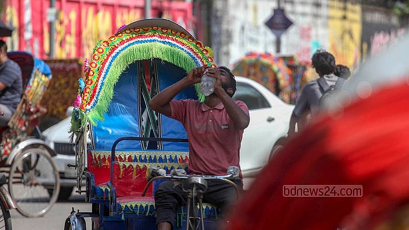 গরমের মধ্যে ঢাকা বিশ্ববিদ্যালয়ের স্বোপার্জিত স্বাধীনতা চত্বরের সামনে পানি বোতলে ভরে পান করছেন রিকশাচালকরা