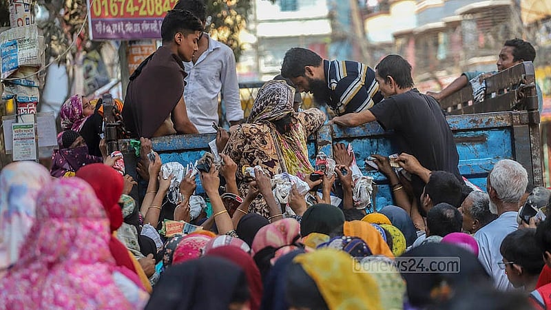 টিসিবির পণ্য শেষ হওয়ার আশঙ্কায় আগে পেতে ট্রাকের পেছনে চড়ে বসেন অনেকে। সোমবার ঢাকার দক্ষিণ বনশ্রী থেকে তোলা