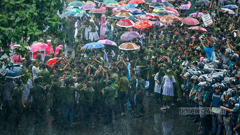 শাহবাগ মোড় বুধবার দুপুরে অবরোধ করে ঝুম বৃষ্টির মধ্যে একদিকে শিক্ষার্থীরা যখন স্লোগান দিচ্ছিলেন তখন পাশেই দাঁড়িয়ে পুলিশ