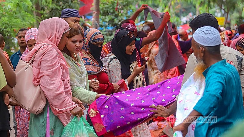 রাজধানীর মতিঝিল আইডিয়াল স্কুল অ্যান্ড কলেজের সামনে শুক্রবার হলিডে মার্কেটে পোশাক দেখছেন ক্রেতারা