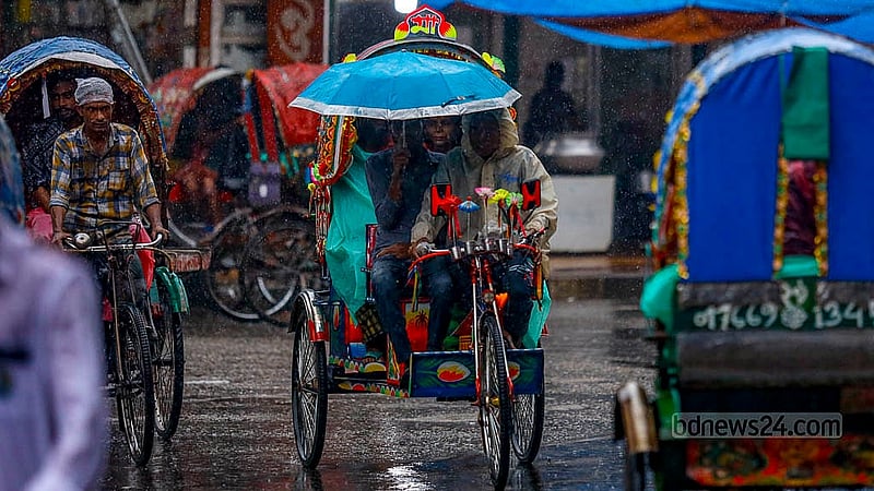 ঢাকার মোহাম্মদপুর বাসস্ট্যান্ড এলাকায় বৃষ্টি থেকে বাঁচতে পলিথিন গায়ে এক রিকশা চালক