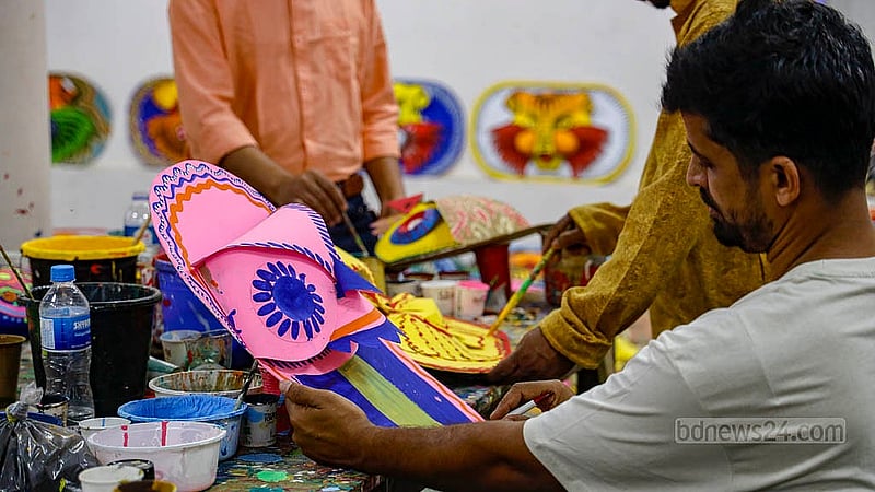 পহেলা বৈশাখ সামনে রেখে ঢাকা বিশ্ববিদ্যালয়ের চারুকলা অনুষদে মঙ্গল শোভাযাত্রার প্রস্তুতি চলছে; কাগজের তৈরি মুখোশে লাগানো হচ্ছে রঙ