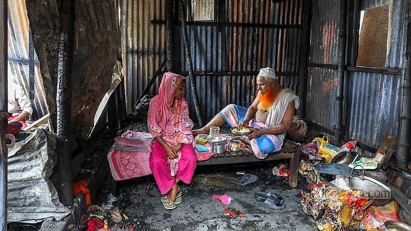 ঢাকার মিরপুরে ভাসানটেক বস্তিতে রোববার সন্ধ্যায় লাগা আগুনে পুড়ে গেছে ঘর। পোড়া ঘরের মধ্যে বসে খাওয়া হচ্ছে দুপুরের খাবার।