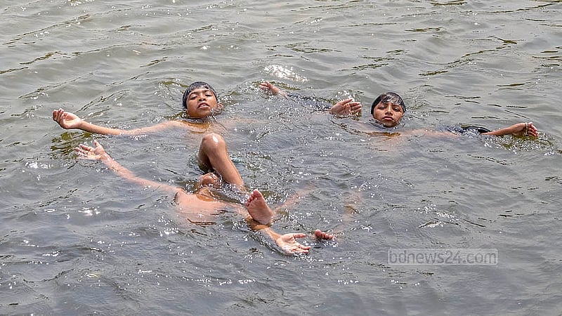 তীব্র গরমে রাজধানীর সোহরাওয়ার্দী উদ্যানের জলাশয়ে পানিতে ভিজতে দেখা যায় শিশুদের
