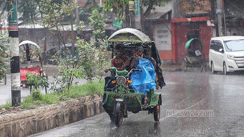 ঢাকায় বৃষ্টির মধ্যে শরীরে পলিথিন জড়িয়ে রিকশা চালান অনেকে। সোমবার মীরহাজিরবাগ এলাকা থেকে তোলা