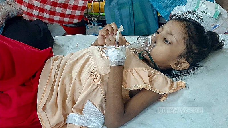 বাংলাদেশ শিশু হাসপাতাল ও ইনস্টিটিউটের ওয়ার্ডে জ্বর ও শ্বাসকষ্ট আক্রান্ত এক শিশু। গরম-ঠান্ডায় এমন রোগী বেড়েছে হাসপাতালে