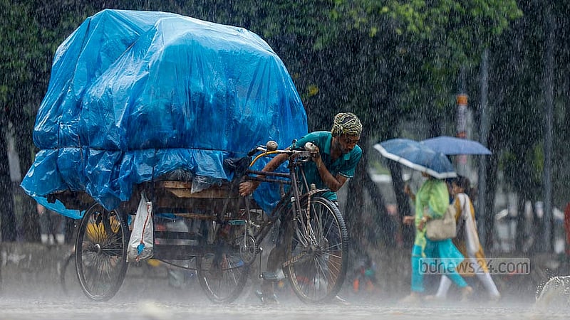 মালামাল নিয়ে ফেরার সময় বৃষ্টি থেকে রক্ষায় পলিথিন দিয়ে ভ্যানের পণ্য মুড়িয়ে গন্তব্যে যাচ্ছেন এক ভ্যানচালক