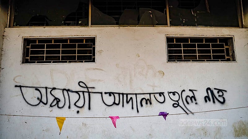 পুরান ঢাকার বকশীবাজারে আলিয়া মাদ্রাসা মাঠে স্থাপিত বিশেষ আদালতের বাইরের দেওয়ালে কালো রঙ দিয়ে লেখা হয়েছে ‘অস্থায়ী আদালত তুলে নেও’
