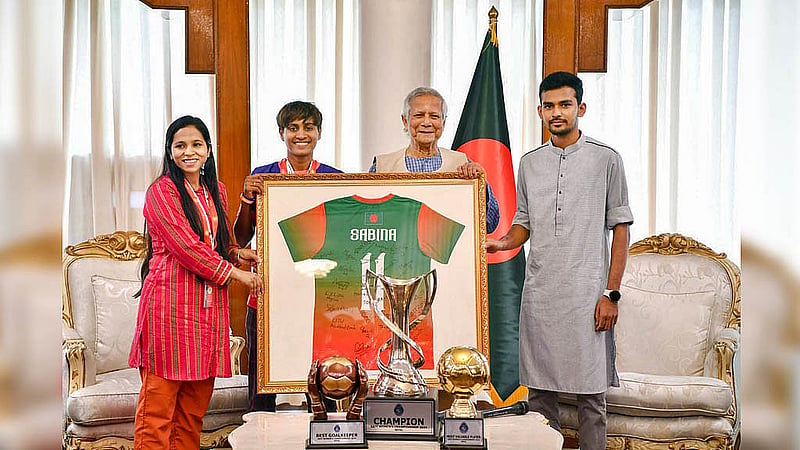 ফ্রেমে বাঁধা জার্সি আর চ্যাম্পিয়ন ট্রফি নিয়ে বাংলাদেশ নারী ফুটবল দলের অধিনায়ক সাবিনা খাতুন শনিবার প্রধান উপদেষ্টা মুহাম্মদ ইউনূসের সঙ্গে ফটোসেশনে অংশ নেন