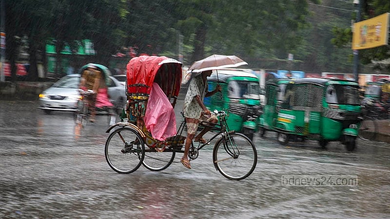 ঢাকা বিশ্ববিদ্যালয় এলাকায় শনিবার ঝুম বৃষ্টির মধ্যে ছাতা হাতে এক রিকশা চালক