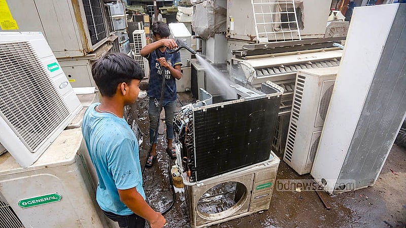 পরিষ্কার করা হচ্ছে এসির আউটেডোর ইউনিট। পুরান ঢাকার ধোলাইখালের পাঁচভাই ঘাট লেনে পুরনো এসি বিক্রির দোকান রয়েছে অর্ধশতাধিক