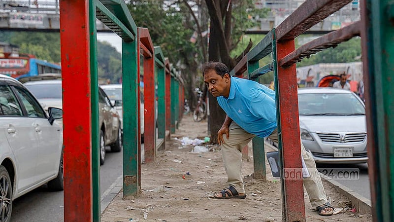 পাশেই ফুট ওভার ব্রিজ, তবু নিউ মার্কেটের সামনে সড়ক বিভাজকের মধ্য দিয়ে পার হচ্ছেন কেনাকাটা করতে আসা মানুষ