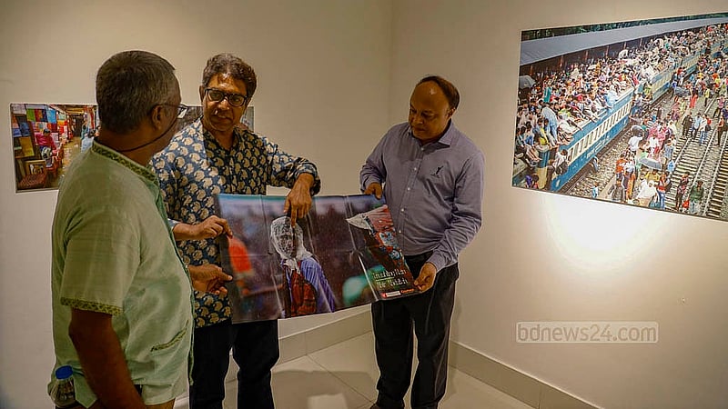 প্রদর্শনীতে আসা দর্শনার্থীদের নিজের তোলা ছবির একটি পোস্টার দেখাচ্ছেন  আলোকচিত্রী আবির আব্দুল্লাহ। বৃহস্পতিবার আলিয়স ফ্রঁসেজ দা ঢাকার লা গ্যালারিতে শুরু হয় এ প্রদর্শনী