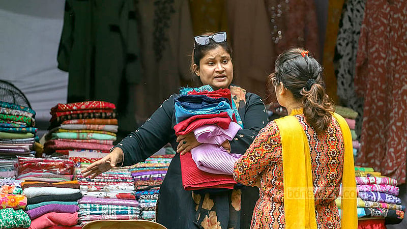 বাংলা একাডেমি প্রাঙ্গণে শনিবার থেকে শুরু হওয়া যুবমেলার একটি স্টলে পণ্য দেখছেন এক নারী