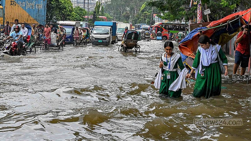ঢাকার নটরডেম কলেজের সামনের সড়কে জলাবদ্ধতা মাড়িয়ে স্কুল শেষে বাসার পথে দুই শিক্ষার্থী।