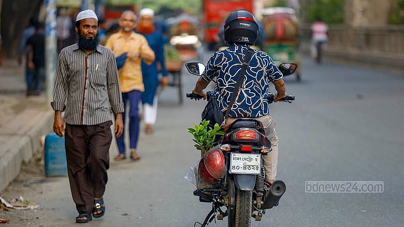 রাজধানীর শিশু একাডেমির দেয়াল ঘেঁষা ফুটপাত থেকে পছন্দের গাছ কিনে মোটরসাইকেলের পেছনে করে নিয়ে যাচ্ছেন এক ব্যক্তি