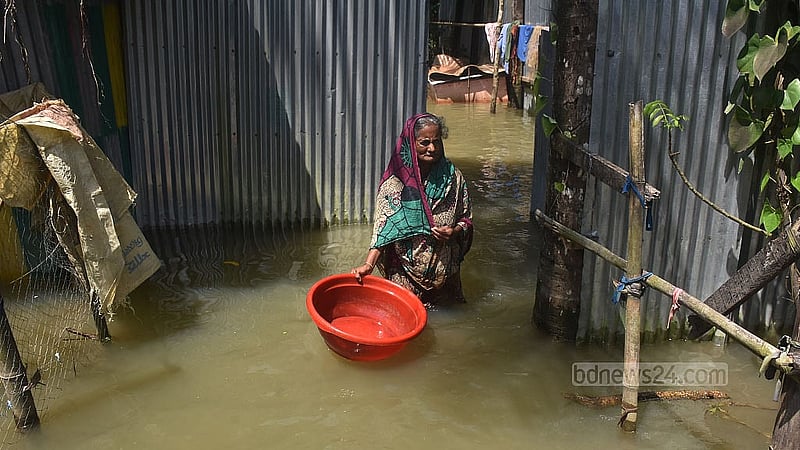 বন্যার অষ্টম দিনেও ফেনীর বিরলী গ্রামে বাড়ির সামনে পানির মধ্যে বেরিয়ে আসছেন এক বৃদ্ধা
