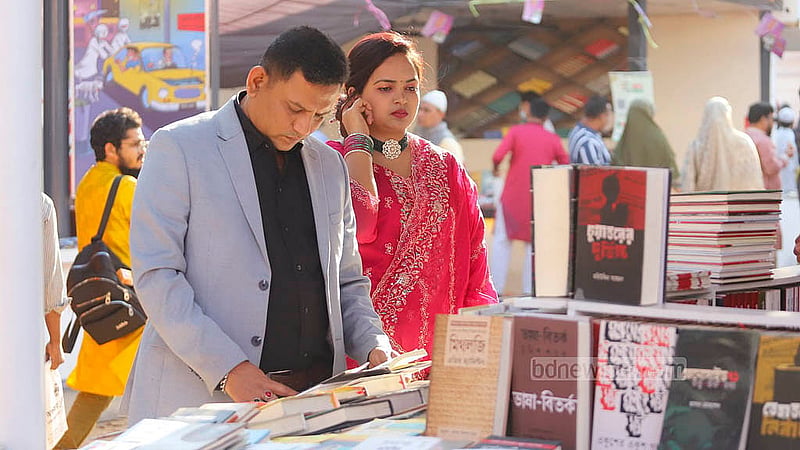 একুশে বই মেলার সোহরাওয়ার্দী উদ্যান প্রাঙ্গণের বিভিন্ন স্টল ঘুরে বই দেখছেন দর্শনার্থীরা
