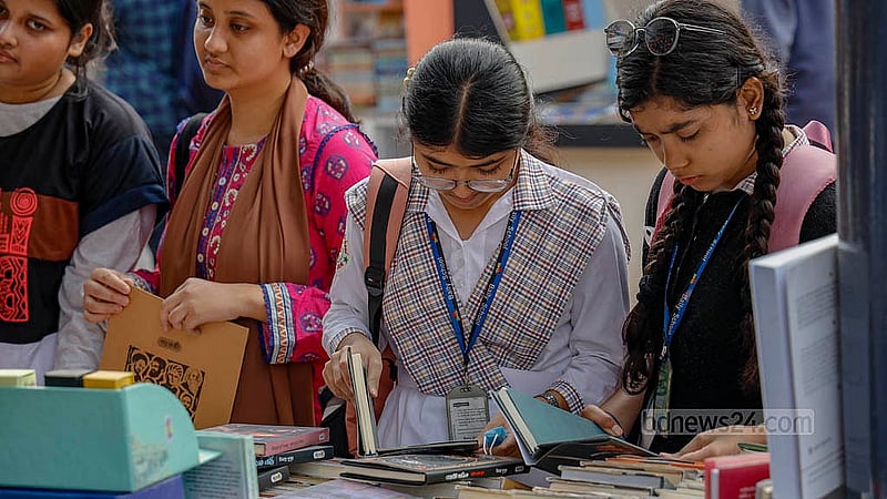 সোহরাওয়ার্দী উদ্যানে বইমেলায় মঙ্গলবার বই দেখছেন দুই শিক্ষার্থী