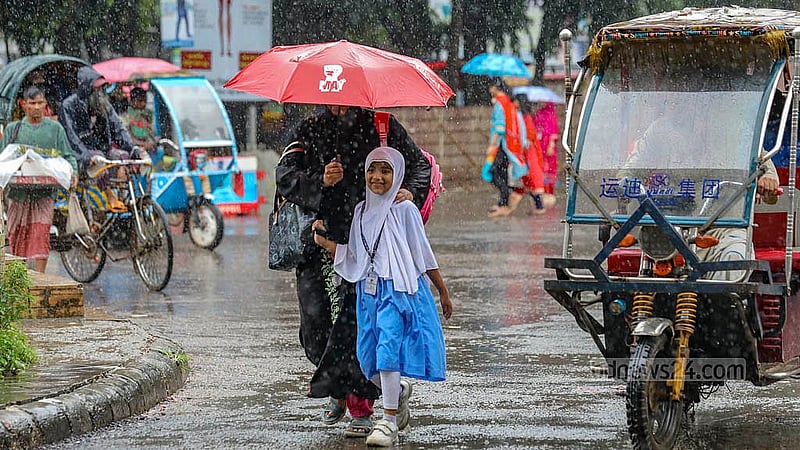 ঢাকা বিশ্ববিদ্যালয়ের টিএসসি এলাকায় মঙ্গলবার দুপুরে ঝুম বৃষ্টির মধ্যে ছাতা মাথায় চলতে দেখা যায় মা-মেয়েকে
