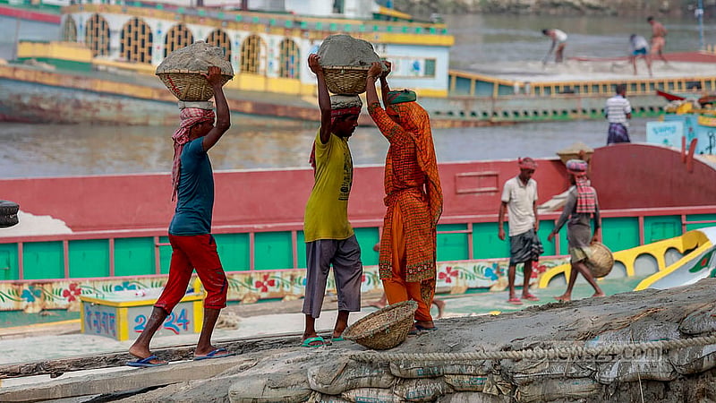 টুকরি বোঝাই বালু মাথায় করে নিয়ে জাহাজ থেকে ঘাটে তুলে দেন শ্রমিকরা