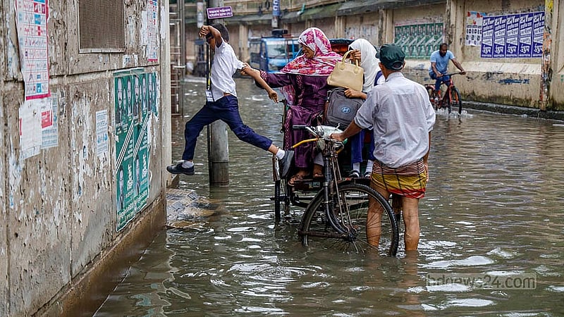 বাসার সামনের সড়কে জমেছে পানি। স্কুল থেকে ফেরা এক শিক্ষার্থী রিকশা থেকে লাফ দিয়ে নামছে। পুরান ঢাকার হোসেনী দালান রোডে তোলা।