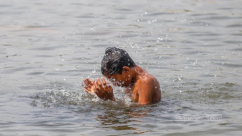গরম থেকে স্বস্তি পেতে রাজধানীর সোহরাওয়ার্দী উদ্যানের জলাশয়ে গোসল করতে দেখা যায় ছোট-বড় অনেকেই