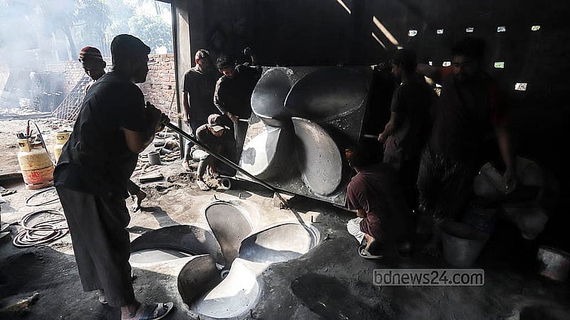 ঢাকার কেরানীগঞ্জের চরকালীগঞ্জে একটি কারখানায় প্রপেলার তৈরির জন্য মেঝেতে ছাঁচ তৈরি করছেন শ্রমিকরা
