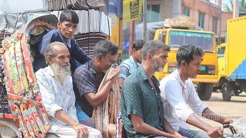 রাজধানীর বাবুবাজার-গাবতলী বেড়িবাঁধে ধুলা থেকে বাঁচতে রিকশায় এক যাত্রী নাক চেপে ধরে আছেন লুঙ্গি দিয়ে