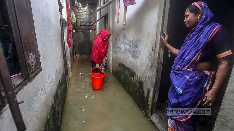 বৃষ্টিতে শনিবার তলিয়েছে ডেমরার মুসলিম নগর এলাকার সড়ক ও বাসাবাড়ি; এর মধ্যেই কাজ করছেন এক নারী
