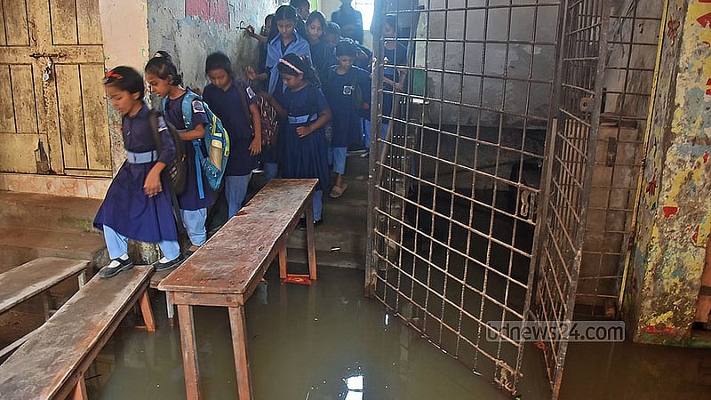চট্টগ্রাম পশ্চিম বাকলিয়া সরকারি প্রাথমিক বিদ্যালয়ে পানির মধ্যে বেঞ্চ বসিয়ে স্কুল ভবনে প্রবেশ করতে হয় শিক্ষক-শিক্ষার্থীদের