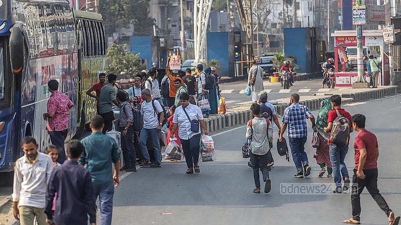সড়ক বিভাজকে বাসের অপেক্ষায় দাঁড়িয়ে মানুষ। স্বজনদের সঙ্গে ঈদ উদযাপন করতে ঢাকা ছাড়বেন তারা। মঙ্গলবার রাজধানীর দোলাইর পাড় এলাকা থেকে তোলা