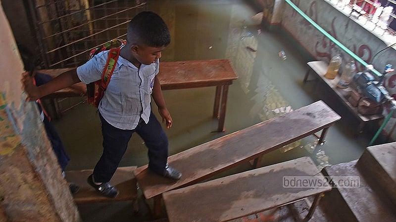 জলাবদ্ধতার কারণে চট্টগ্রাম পশ্চিম বাকলিয়া সরকারি প্রাথমিক বিদ্যালয়ের নিচতলায় ঝুঁকি নিয়ে বেঞ্চের ওপর দিয়ে চলাচল করতে হচ্ছে শিক্ষার্থীদের
