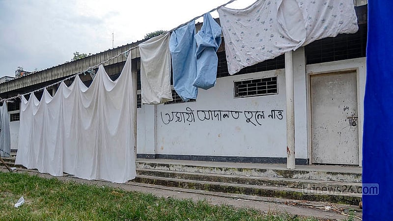 পুরান ঢাকার বকশীবাজারে আলিয়া মাদ্রাসার মাঠের এক পাশে স্থাপিত অস্থায়ী আদালতের সবগুলো কক্ষ বন্ধ। এর সামনের মাঠে শুকানো হচ্ছে কাপড়
