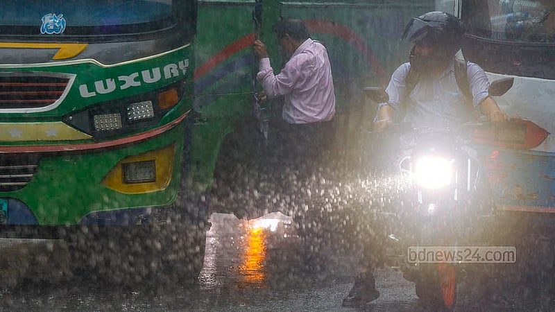 ঢাকার শাহবাগ এলাকায় ঝুম বৃষ্টির মধ্যে বাসে চড়ছেন এক ব্যক্তি