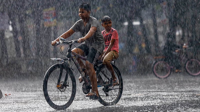 ঢাকা বিশ্ববিদ্যালয়ে এলাকায় বুধবার বিকালে বৃষ্টির মধ্যে এক সাইকেলে দুই শিশু