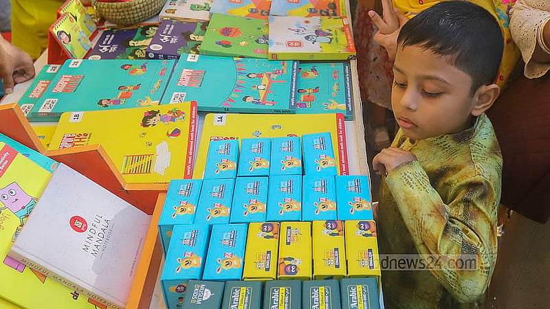 একুশে বই মেলার সোহরাওয়ার্দী উদ্যান প্রাঙ্গণে শিশু কর্নারের বিভিন্ন স্টলে বই দেখছে শিশুরা