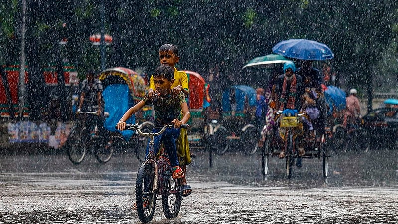 ঢাকা বিশ্ববিদ্যালয়ে এলাকায় রোববার দুপুরে আষাঢ়ী বৃষ্টির মধ্যে এক সাইকেলে দুই শিশু