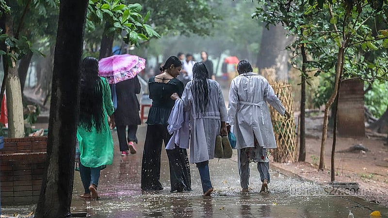 মুষলধারে বৃষ্টিতে মঙ্গলবার রাজধানীর ধানমন্ডি লেকে ভিজতে দেখা যায় অনেককে