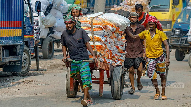 ভরদুপুরে তীব্র রোদে মালবোঝাই ঠেলাগাড়ি নিয়ে গন্তব্যের পথে মজুররা